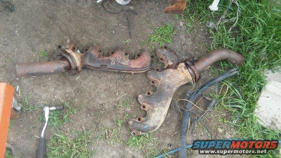 Pair of rusty exhaust manifolds on the ground