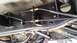 1988 Ford Bronco - Underside view of a vehicle's brake cable system, showing the routing and attachment points.