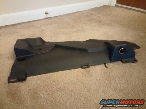 Black car floor mat on tan carpet