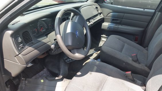Interior of a 2001 Ford Crown Victoria, showing the dashboard, steering wheel, and front seats