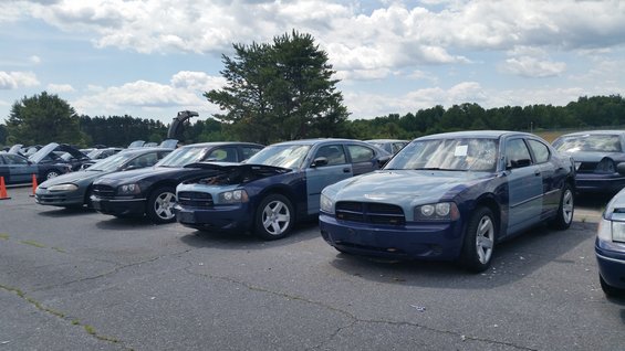 Blue Dodge Charger with a light blue hood and fender, parked in a lot with other vehicles