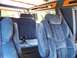2000 Ford E150 - The plush blue interior of a van, captain's chairs and wood trim accents.