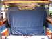 2000 Ford E150 - The interior of a van is visible, with blue seats and wood paneling.