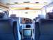 2000 Ford E150 - The interior of a van shows plush blue seats and a wood-accented dashboard with a built-in television.