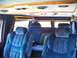 2000 Ford E150 - Interior view of a van with multiple rows of blue velour seats and wood trim accents.