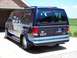 2000 Ford E150 - Rear view of a dark blue 2000 Ford E150 van with a spare tire visible under the bumper.