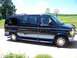 2000 Ford E150 - Side view of a dark blue Ford van parked on a driveway with a basketball hoop in the background.