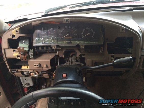 Disassembled dashboard of a 1992 Ford Bronco with exposed wiring and gauges