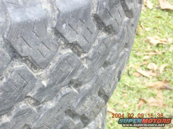 close up of a tire tread with a date stamp and website on the bottom right