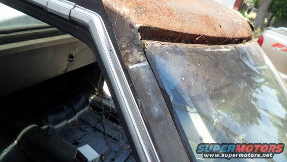 rusted car roof and windshield frame, interior visible