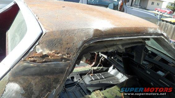 Rusted car roof and interior, showing extensive corrosion and exposed wiring