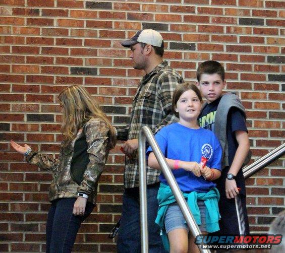 People on stairs in front of a brick wall