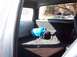 1990 Ford Bronco - The rear interior of a vehicle features a blue tank and a speaker, with other vehicles seen through the window.
