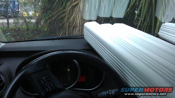 Interior view of dashboard and steering wheel with a large white object on the passenger side