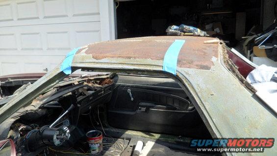 Interior of a car with a rusty roof, showing the dashboard and door panel