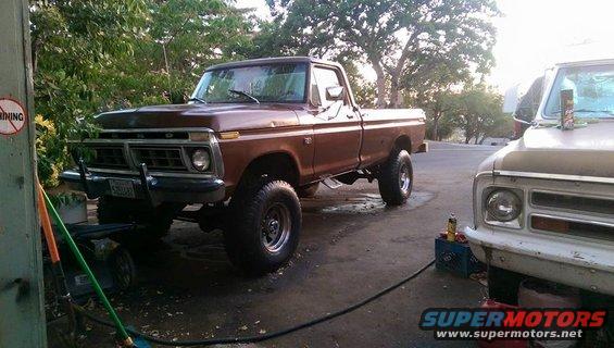 Brown lifted pickup truck, 3/4 front view. Grille suggests 1975 model year