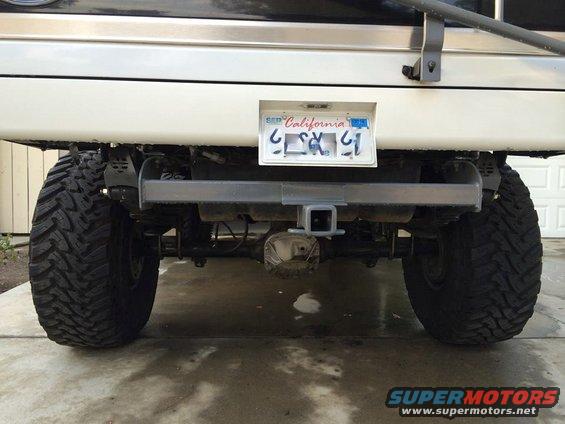 Rear view of lifted SUV with large tires, trailer hitch, and California license plate