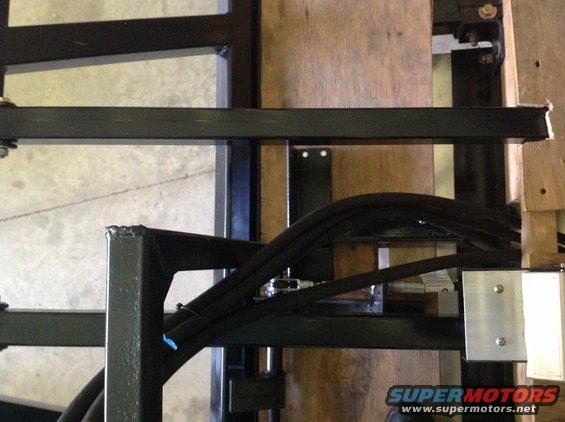 metal frame with black hoses attached, some bolts visible