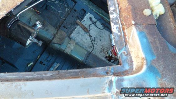 Interior view of a rusty vehicle showing steering column and a can of lubricant