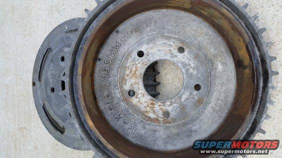 Close-up of a rusty brake drum with part number markings