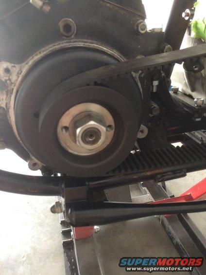 Motorcycle engine pulley with a belt and a large nut