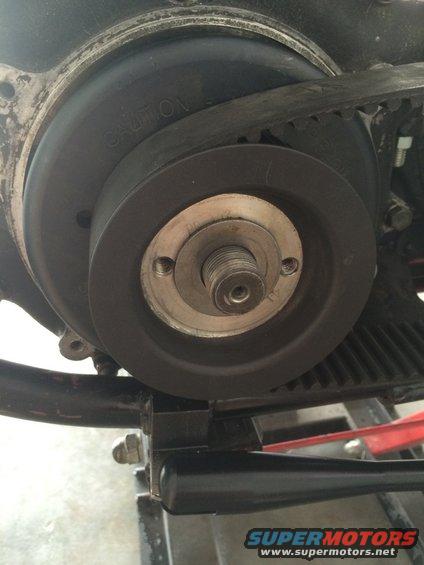 Motorcycle belt drive pulley with 'CAUTION' text visible