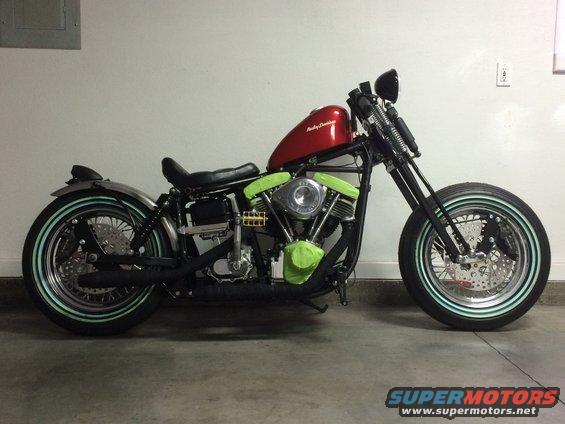 Side view of a custom Harley-Davidson motorcycle with a red fuel tank and green engine covers