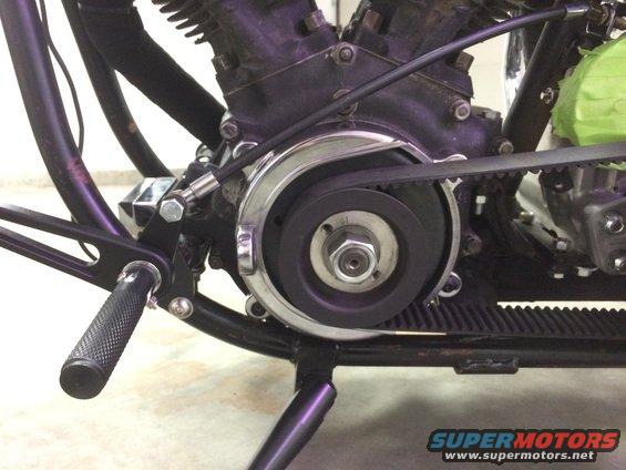 Motorcycle engine with belt drive system, black frame, and footpeg