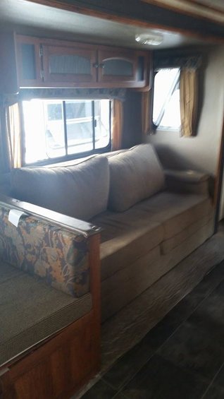 RV interior with sofa, cabinets, and windows