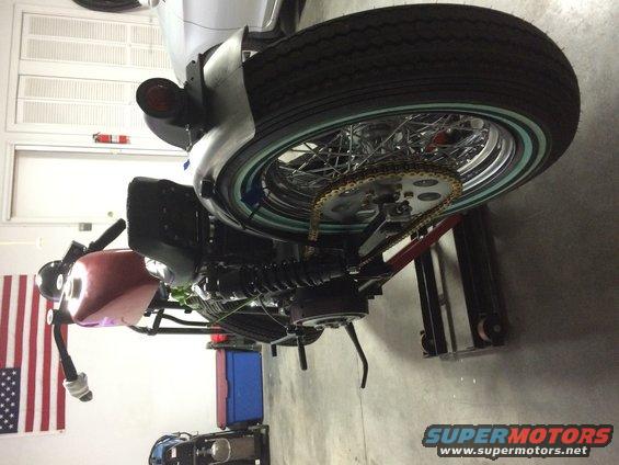 Motorcycle rear wheel with gold chain and sprocket, viewed from above