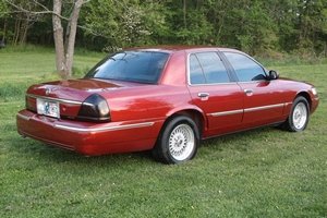 Red 2001 Mercury Grand Marquis sedan, rear quarter view, parked on grass