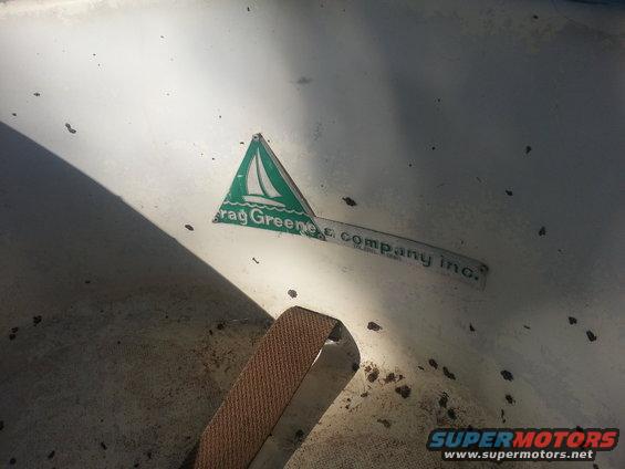 Green triangle sticker with a sailboat and text 'Crag Greene & Company Inc.' on a white surface