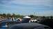 2004 Ford Crown Victoria - A car show with multiple vehicles and attendees under a partly cloudy sky.
