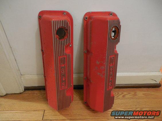 Two red Shelby valve covers with vertical fins and raised lettering