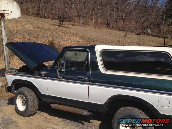 Ford Bronco with hood open, parked outside