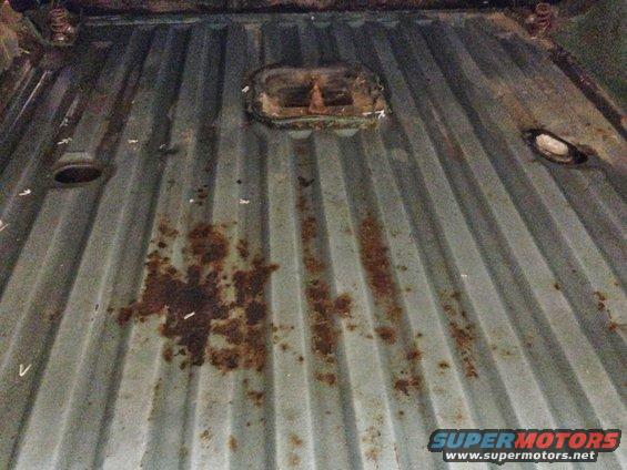Corrugated metal floor with rust spots and a central metal fixture