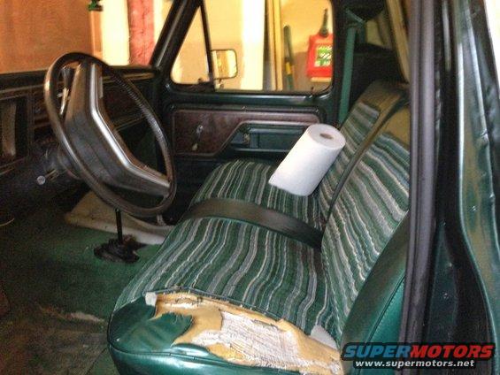 Interior of 1979 Ford Bronco with green striped seats and torn driver's side cushion