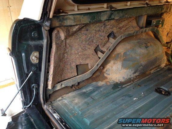 Green interior cargo area of a 1978 Ford Bronco with exposed insulation and rust