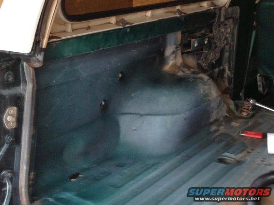 1979 Ford Bronco cargo area floor with dark green interior panels and visible wheel well