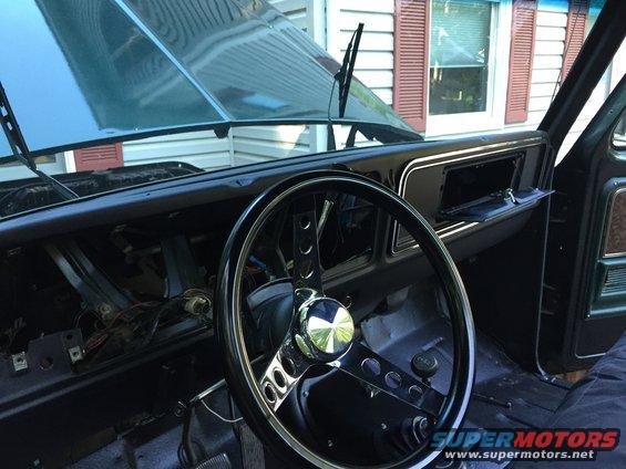 1979 Ford Bronco interior with dashboard removed, showing wiring and a chrome steering wheel