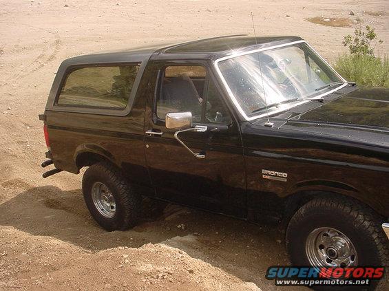 Black 1988 Ford Bronco parked on dirt road. Side view shows removable hardtop