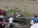 1988 Ford Bronco - A muddy Jeep Wrangler is stuck in the dirt while onlookers observe the scene.