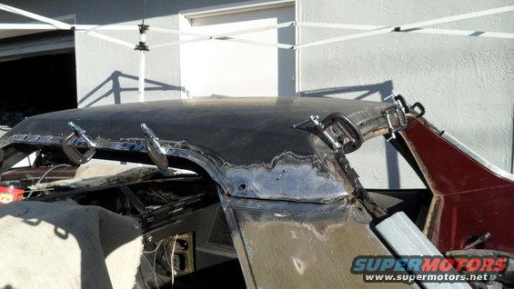 Car roof undergoing repair with clamps holding metal in place