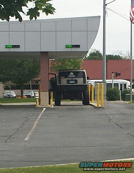 SUV with large tires parked at a drive-thru window