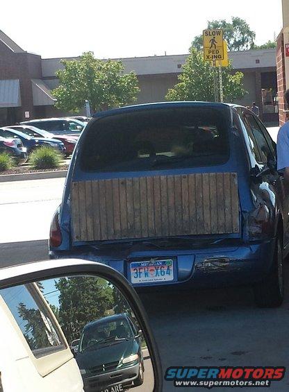 Blue hatchback with wooden paneling on rear hatch, Michigan license plate 3FWX64