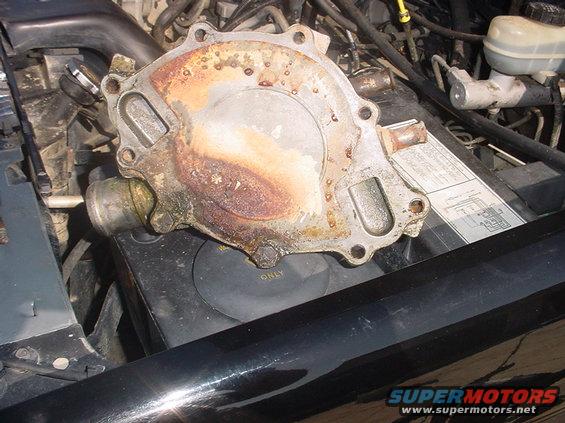 rusty water pump sitting on top of engine components