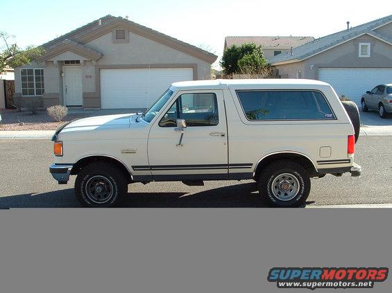 White Ford Bronco parked in front of a suburban house