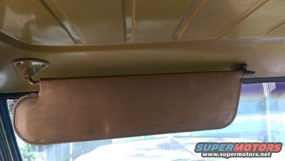 Interior shot of a vehicle's tan sun visor and headliner