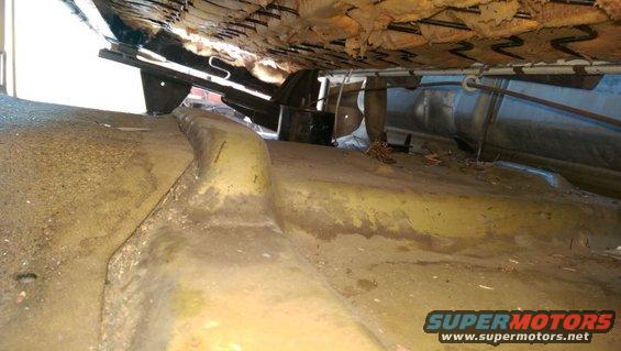 View under a vehicle seat showing springs and floor pan. Supermotors.net logo visible
