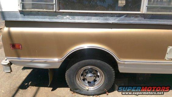 Gold and white pickup truck side view, showing rear wheel and bed